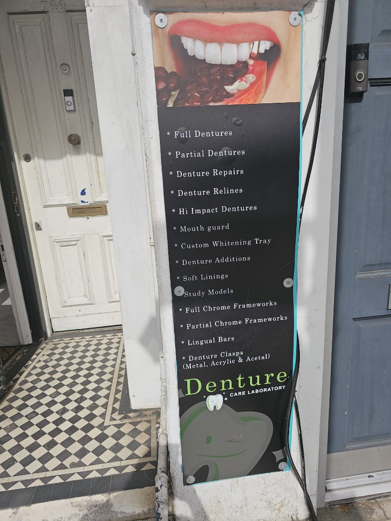 Outdoor sign for Denture Care Laboratory listing laboratory services